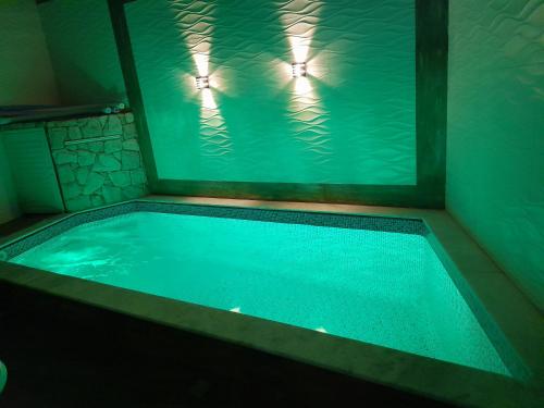 una piscina de agua con dos luces en una bañera en DISPONIVEL NATAL E REVEILLON - Casa Linda e Aconchegante com Piscina -Aquecimento Solar o Ano Todo Perto da Praia, en Praia Grande