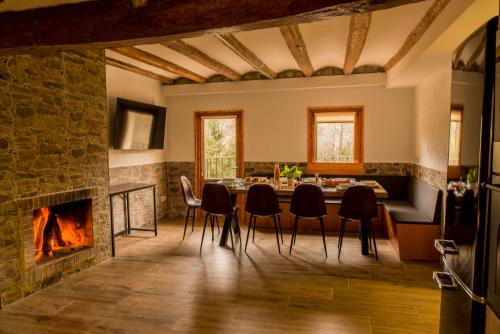 聖保德塞古列斯的住宿－Casa rural Can Miralter，一间带壁炉和桌椅的用餐室
