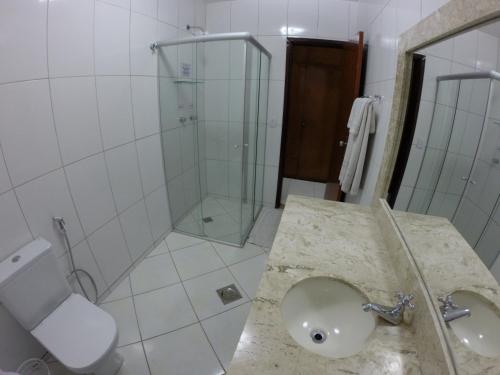 a bathroom with a shower and a sink and a toilet at Alvimar Hotel in Sobradinho