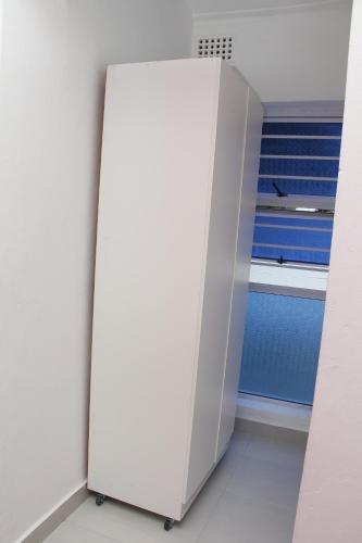 a white refrigerator in a room with a bed at The White House Lodge in Cape Town
