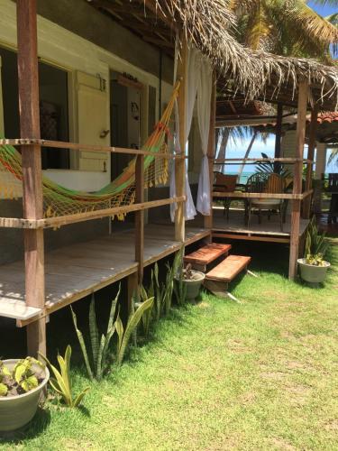 a hammock on the side of a house at Parador Algaroba in Japaratinga
