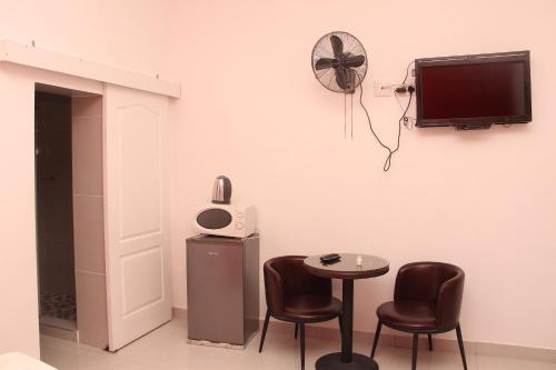 a room with two chairs and a table and a tv at The White House Lodge in Cape Town