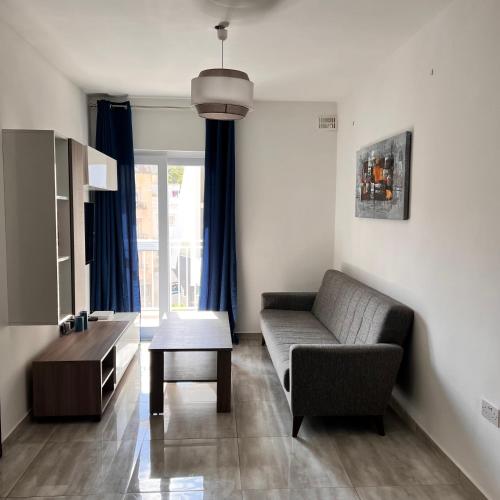 a living room with a couch and a table at F3 Room 2, Private Room two single beds shared bathroom in Msida