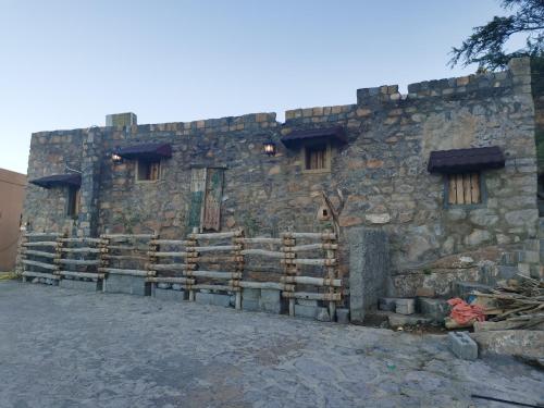a stone building with a fence in front of it at ROSES HOUSE OMAN in Jabal Al Akhdar