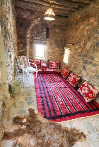 a living room with a couch and a red carpet at ROSES HOUSE OMAN in Jabal Al Akhdar