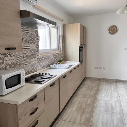 a kitchen with a microwave and a stove in it at F3 Room 3, Private Room two single beds shared bathroom in Msida