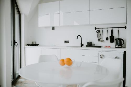 a white kitchen with a table and oranges on it at Diamond 4 Divcibare in Divčibare