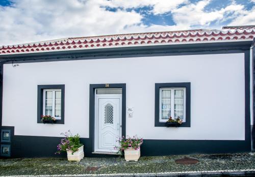 ein weißes Haus mit zwei Fenstern und einer Tür in der Unterkunft Maré Alta - Casa de Férias in Maia