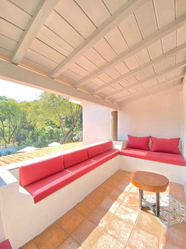 a red couch in a room with a window at Hotel Cala Blanca Cuernavaca in Cuernavaca