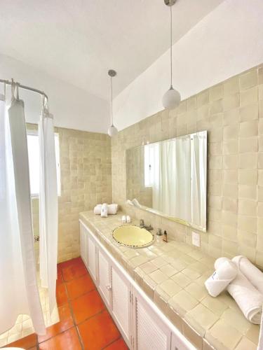 a bathroom with a sink and a large mirror at Hotel Cala Blanca Cuernavaca in Cuernavaca