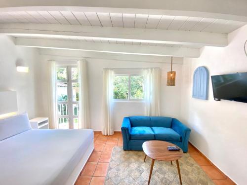 een slaapkamer met een bed en een blauwe stoel bij Hotel Cala Blanca Cuernavaca in Cuernavaca