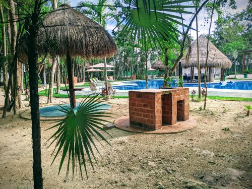 un resort con piscina e palma di 2-Bedroom Condo by the Jungle w/ Swimming pool a Puerto Morelos