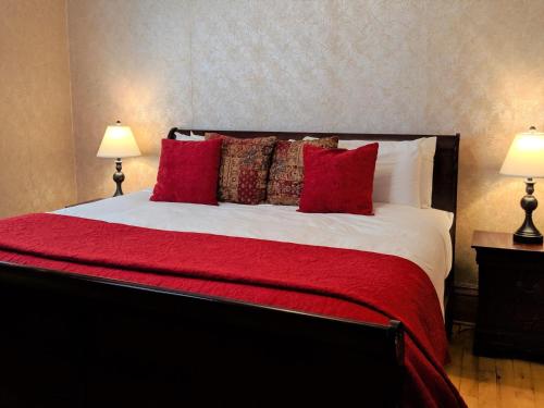 um quarto com uma cama grande com lençóis e almofadas vermelhas em Sagebrush I - Cozy Downtown Home W-patio Dining em Fruita