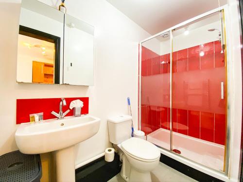 a bathroom with a toilet and a sink and a shower at PHOENIX Apartments in Goole