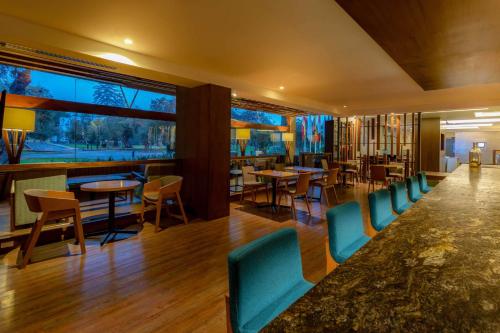 a restaurant with chairs and tables and a bar at Sonesta Hotel El Olivar in Lima