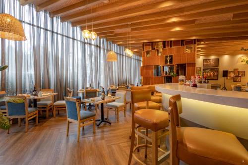 a restaurant with tables and chairs and a bar at Sonesta Hotel Bogotá in Bogotá