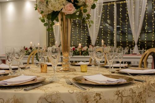 a table with glasses and a vase with flowers at Sonesta Hotel Bogotá in Bogotá