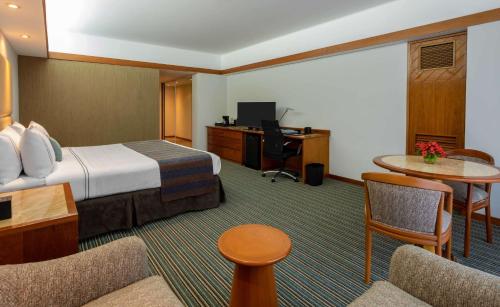 a hotel room with a bed and a desk at Sonesta Hotel El Olivar in Lima