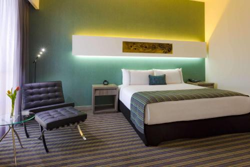 Habitación de hotel con cama y silla en Sonesta Hotel Arequipa en Arequipa