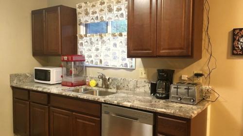 a kitchen counter with a sink and a microwave at Granite Getaway REDUCED PRICE ON TOURS in Juneau