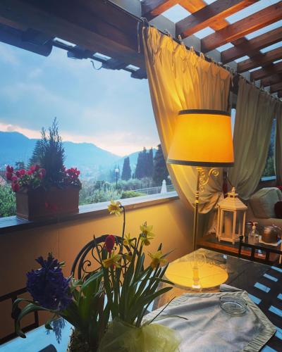 a room with a table with a lamp and a window at Sotto il cielo di Toscana appartamenti in tenuta only adults no pet in Camaiore