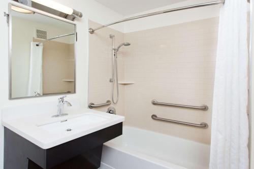 a bathroom with a sink and a shower at Sonesta Simply Suites Dallas Las Colinas in Irving