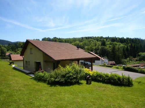 a small house in a field with a grass yard at Sunny holiday home with private garden in Le Haut-du-Them