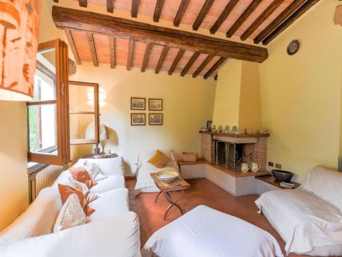 a living room with white couches and a fireplace at Belvilla by OYO Il Fienile in Monterchi
