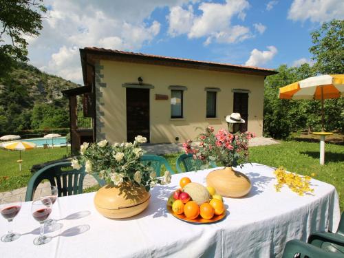 ApecchioにあるBelvilla by OYO Sorgoの白いテーブルクロスと果物をテーブルに載せたテーブル