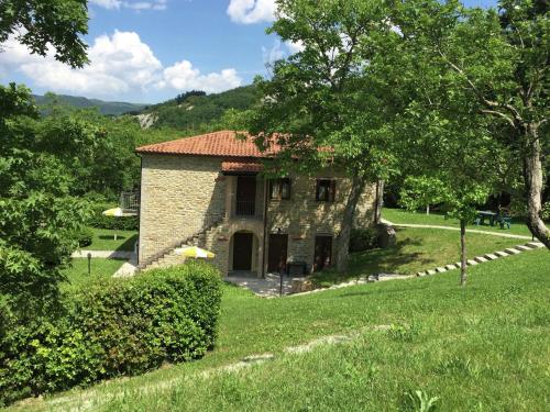 a small stone house in a field with trees at Belvilla by OYO Sorgo in Apecchio