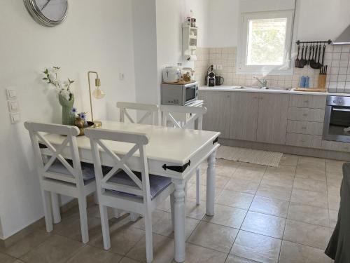 een keuken met een witte tafel en stoelen bij Stylish Villa in Loutra in Loutra