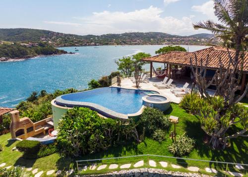 an aerial view of a house with a swimming pool and a lake at Cliffside Luxury Inn in Búzios