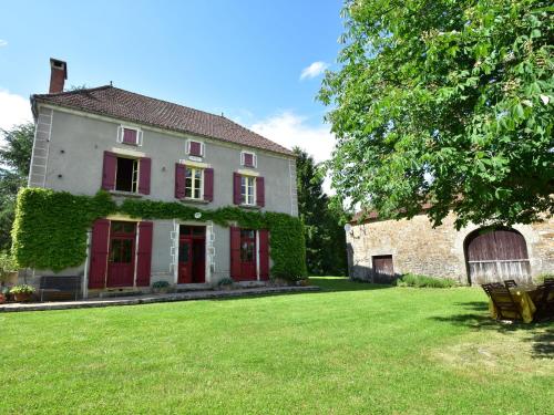 una casa antigua con puertas rojas y un patio en Holiday home with tennis court in Montcl ra, en Frayssinet-le-Gélat