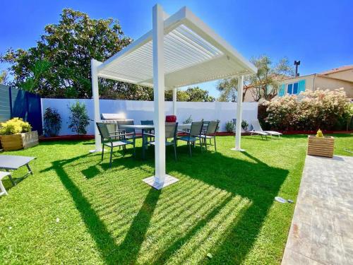 un tavolo e sedie sotto un baldacchino bianco in un cortile di High Standing! 200m2 Private Garden Jacuzzi Sun Bed & Interior Spa a Antibes
