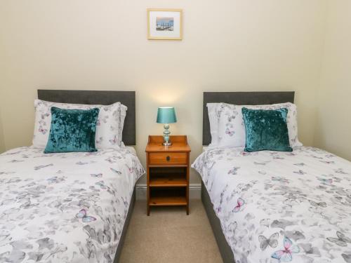 a bedroom with two beds and a night stand at The Cottage in Pickering