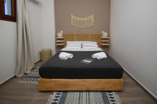 a bedroom with a bed with two towels on it at Syros Luxury Seaview Wellness Suite Finikas in Finikas