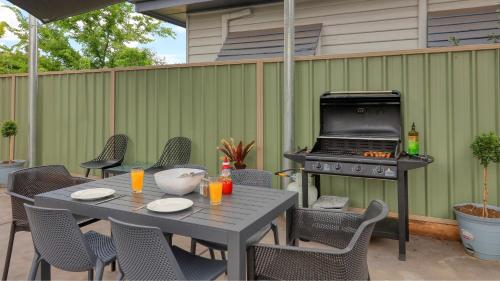 a patio with a grill and a table with chairs at Sun Centre Motel in Swan Hill