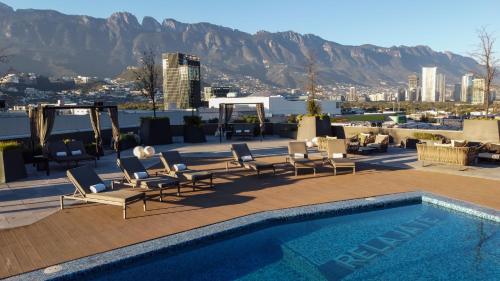 a patio with chairs and a swimming pool on a building at Camino Real Fashion Drive Monterrey in Monterrey