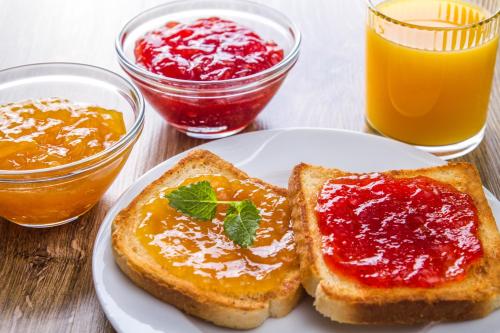 a plate with two pieces of toast with jam and orange juice at Sun Centre Motel in Swan Hill