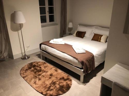 a bedroom with a bed with a brown blanket and a rug at Casa Carducci 33 in Pisa