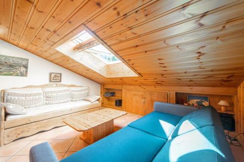 ein Wohnzimmer mit einem blauen Sofa und einem Dachfenster in der Unterkunft Gentiane Furnished flat in Les Houches