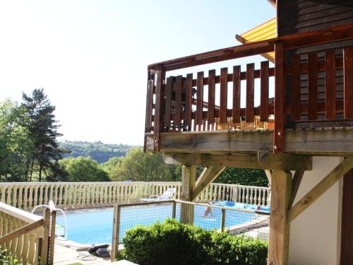 una terrazza sopra una piscina con balcone di Comfortable holiday home near the lake a Beaulieu