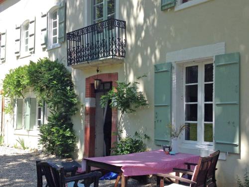 アルティガにあるPicturesque Villa in Artigat with Private Terraceのバルコニー付きの建物の外にテーブルと椅子があります。