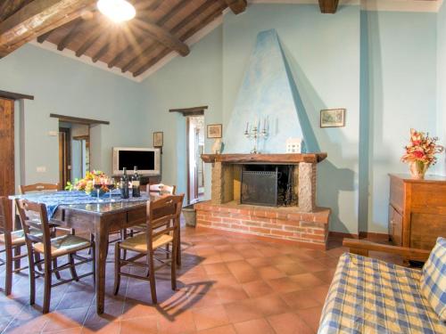 PucciarelliにあるComfy Farmhouse in Castiglione del Lago with Poolのダイニングルーム(テーブル、暖炉付)