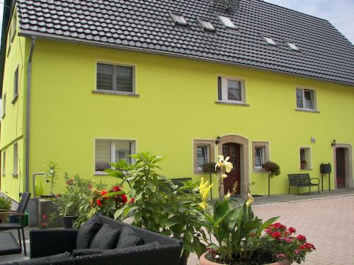 ein gelbes Haus mit schwarzem Dach in der Unterkunft Holiday home in Saxon Switzerland quiet location big garden grilling area in Lichtenhain