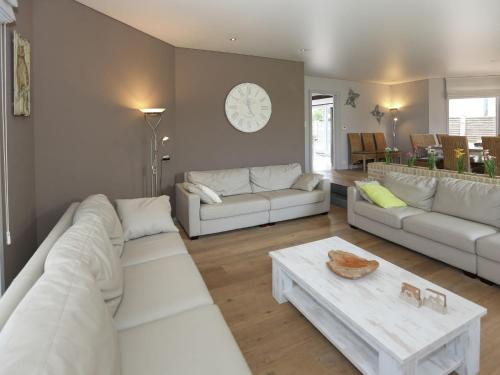 uma sala de estar com sofás brancos e uma mesa em Splendid VIlla in Middelkerke with Sauna bubble bath em Middelkerke