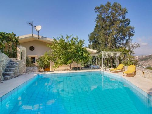- une piscine avec 2 chaises jaunes à côté d'une maison dans l'établissement Luxurious Villa in Malades Crete, à Áyios Síllas