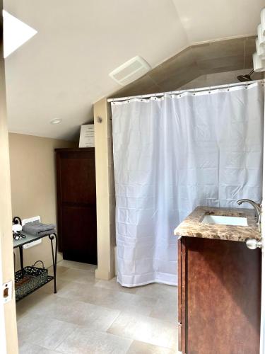 a bathroom with a shower with a white shower curtain at Oceanfront Penthouse with Family & Friends in Salisbury