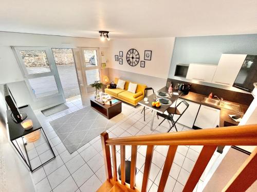 un salon avec un canapé jaune et une table dans l'établissement Charmant duplex proche de la gare, parking gratuit, à Laval