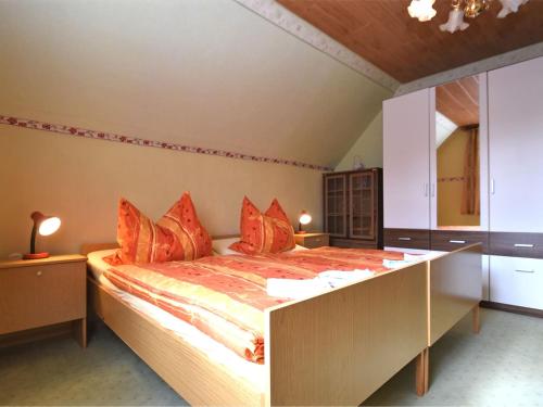 a bedroom with a large bed with orange pillows at Holiday home with terrace in the Harz Mountains in Güntersberge
